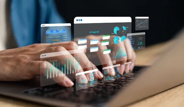 Hands typing on a laptop with dashboard panels layered above the keyboard